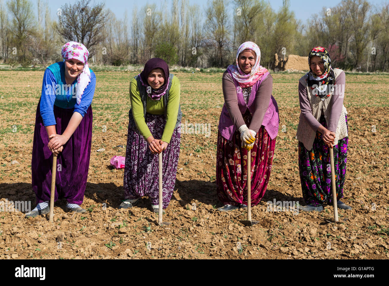 Women working in the field rest leaning on their hoe near Konya, Turkey. Stock Photo
