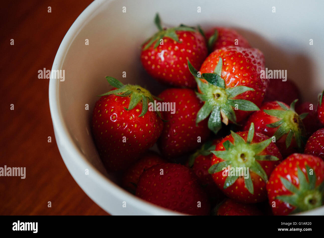 White bowl with organic British strawberries Stock Photo
