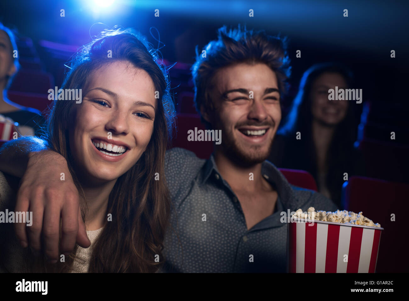 Happy young couple in the movie theater watching a film and smiling, entertainment and togetherness concept Stock Photo