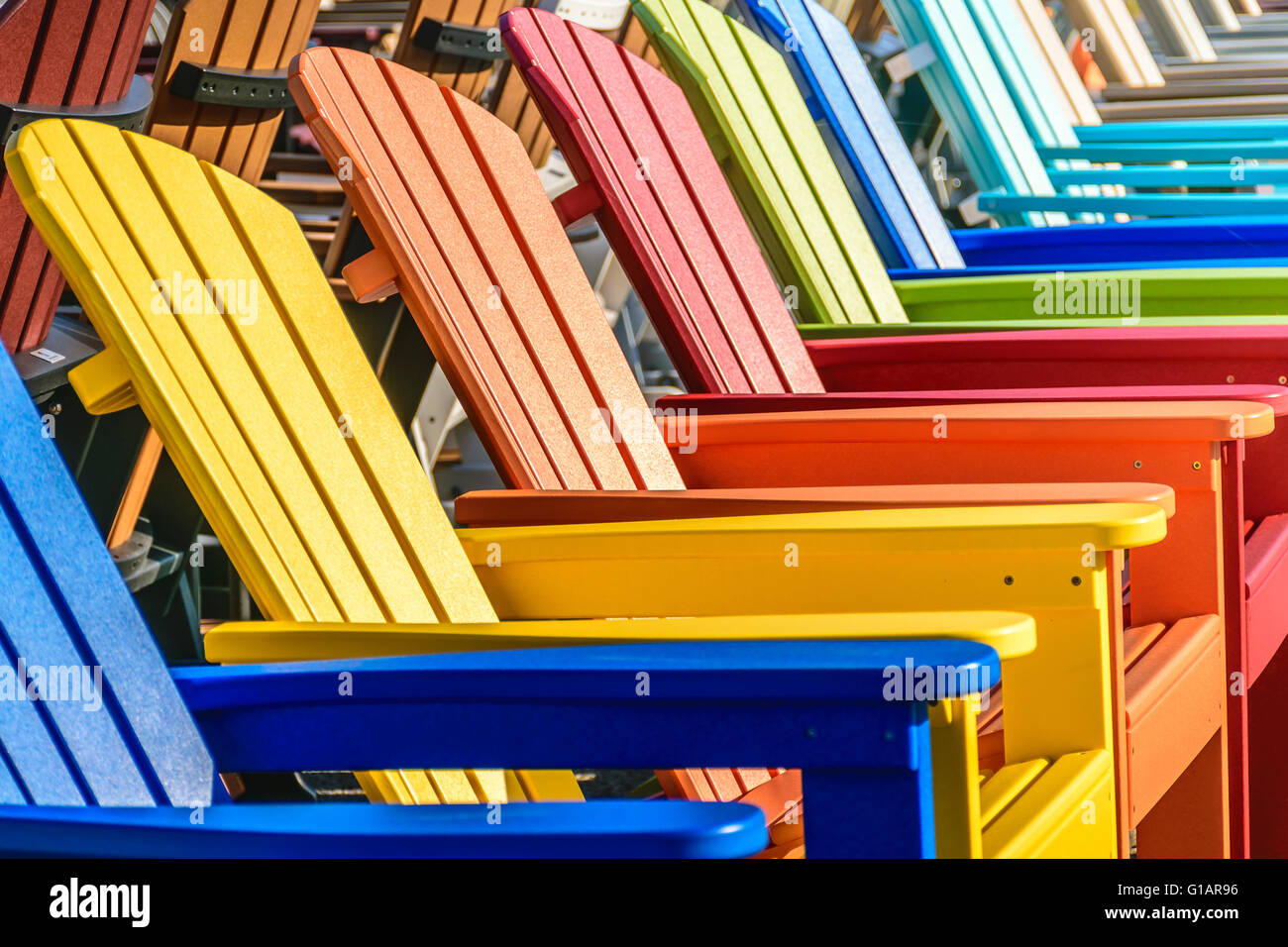 A row of colorful Adirondack chairs Stock Photo