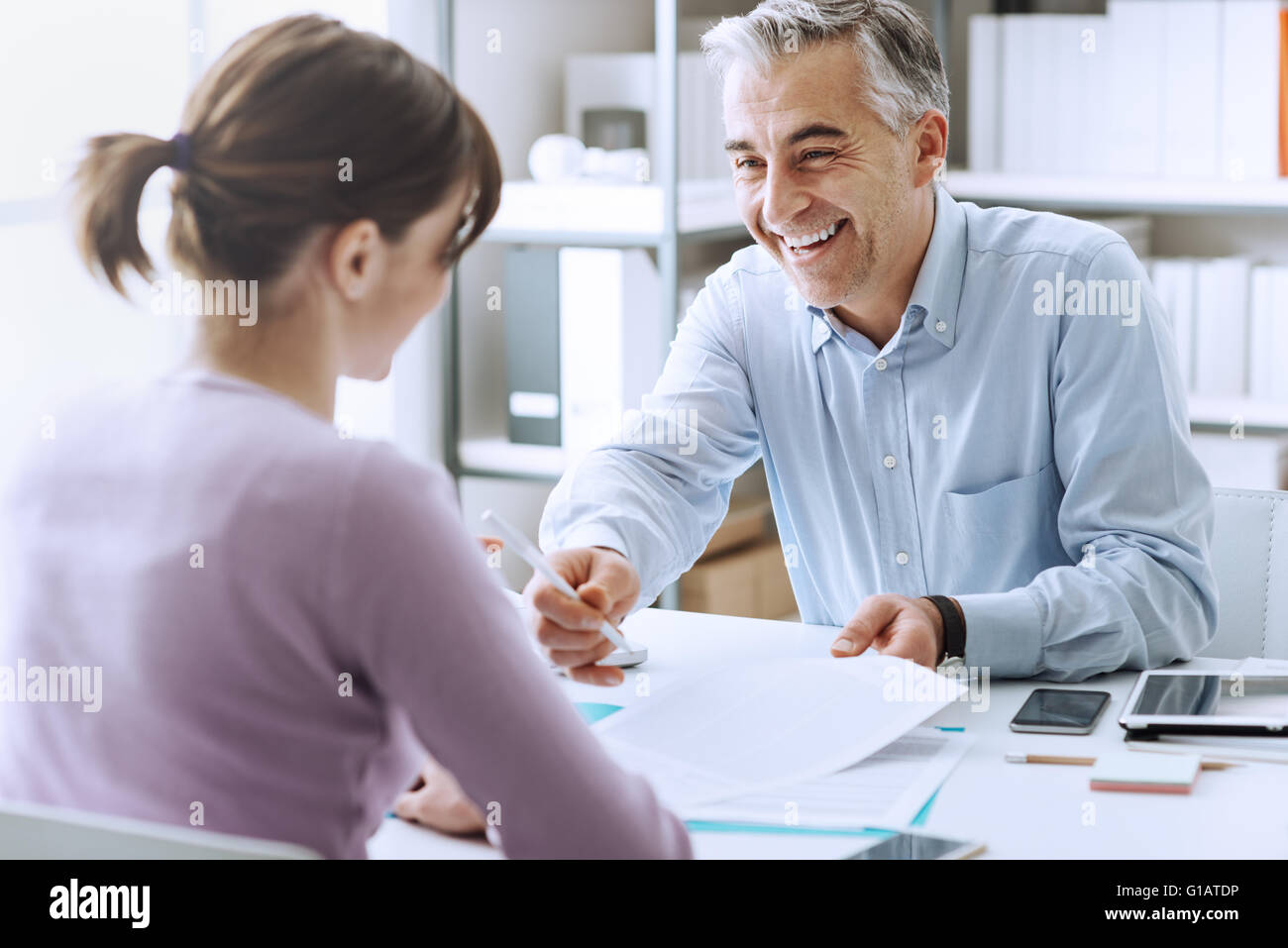 Young woman having a business meeting and signing a contract, recruitment and agreement concept Stock Photo