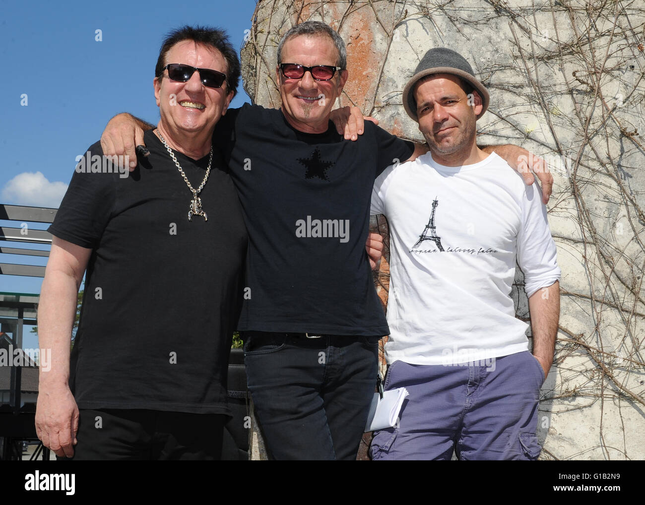 Seeshaupt, Germany. 7th May, 2016. dpa EXCLUSIVE - Tico Torres (L-R), drummer of the group Bon Jovi, Herman Rarebell, former drummer of the Scorpions and music video and film director Maik Marzuk smile as they pose in front of the Berlin Wall during a video shoot for Torres' fashion collection 'Rock Star Baby' in Seeshaupt, Germany, 7 May 2016. Hermann and Torres havbe known each other since the 1980s when Bon Jovi performed as the supporting act of the German music group Scorpions when they went on a four-months concert tour. Photo: Ursula Dueren/dpa/Alamy Live News Stock Photo