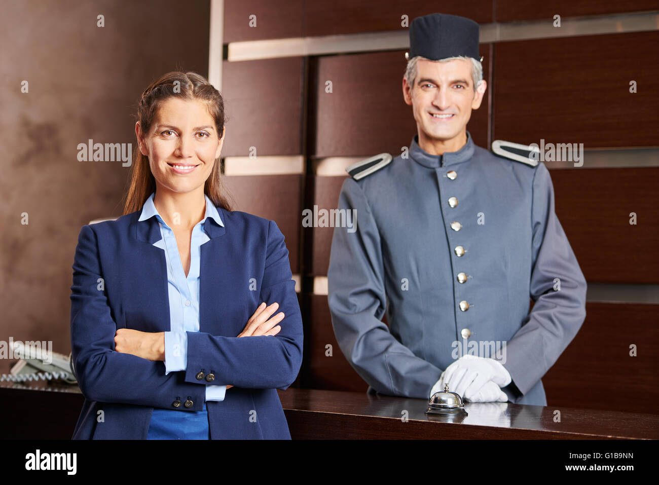 Happy concierge and smiling receptionist in a hotel as team in uniform  Stock Photo - Alamy