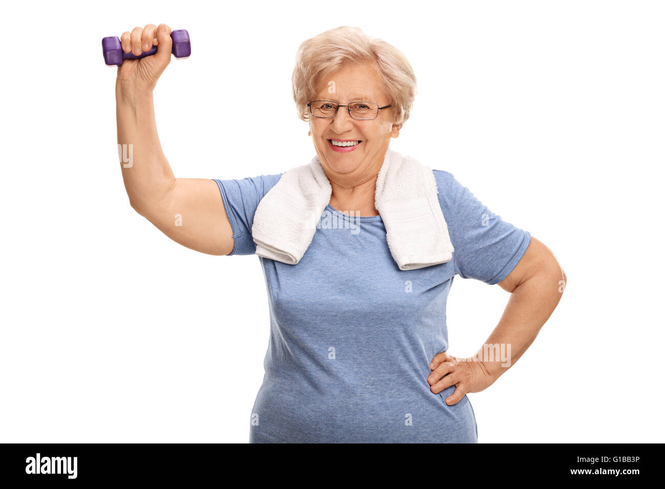Mature lady exercising with a purple dumbbell and looking at the camera isolated on white background Stock Photo