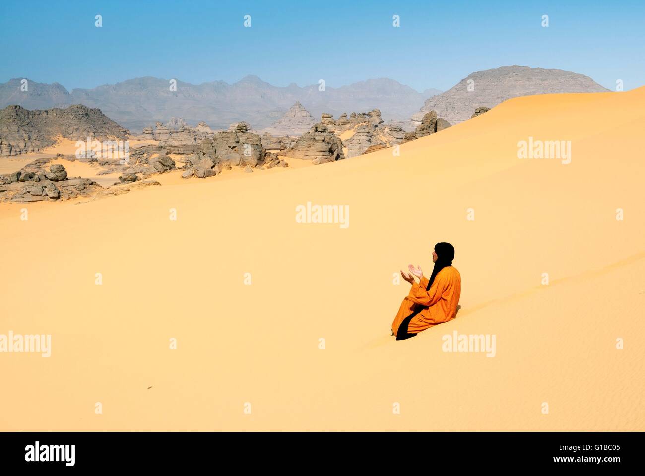 Libya, Sahara Desert, Fezzan, Erg Murzuq, Tuareg or Touareg man praying Allah on the dunes Stock Photo