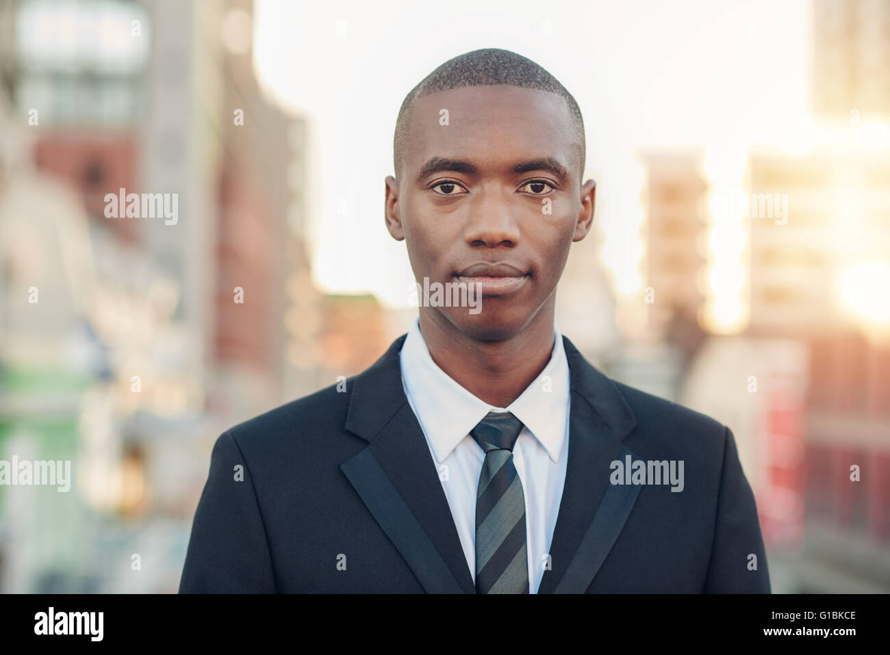 Portrait of a serious young African businessman in a corporate suit and tie, looking at the camera with an expression of confide Stock Photo