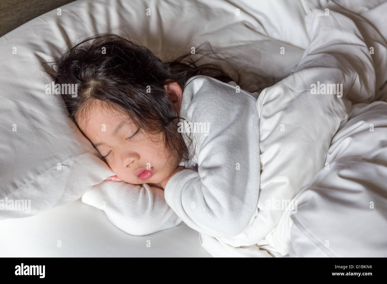Little girl sleeping in bed with white blanket Stock Photo - Alamy