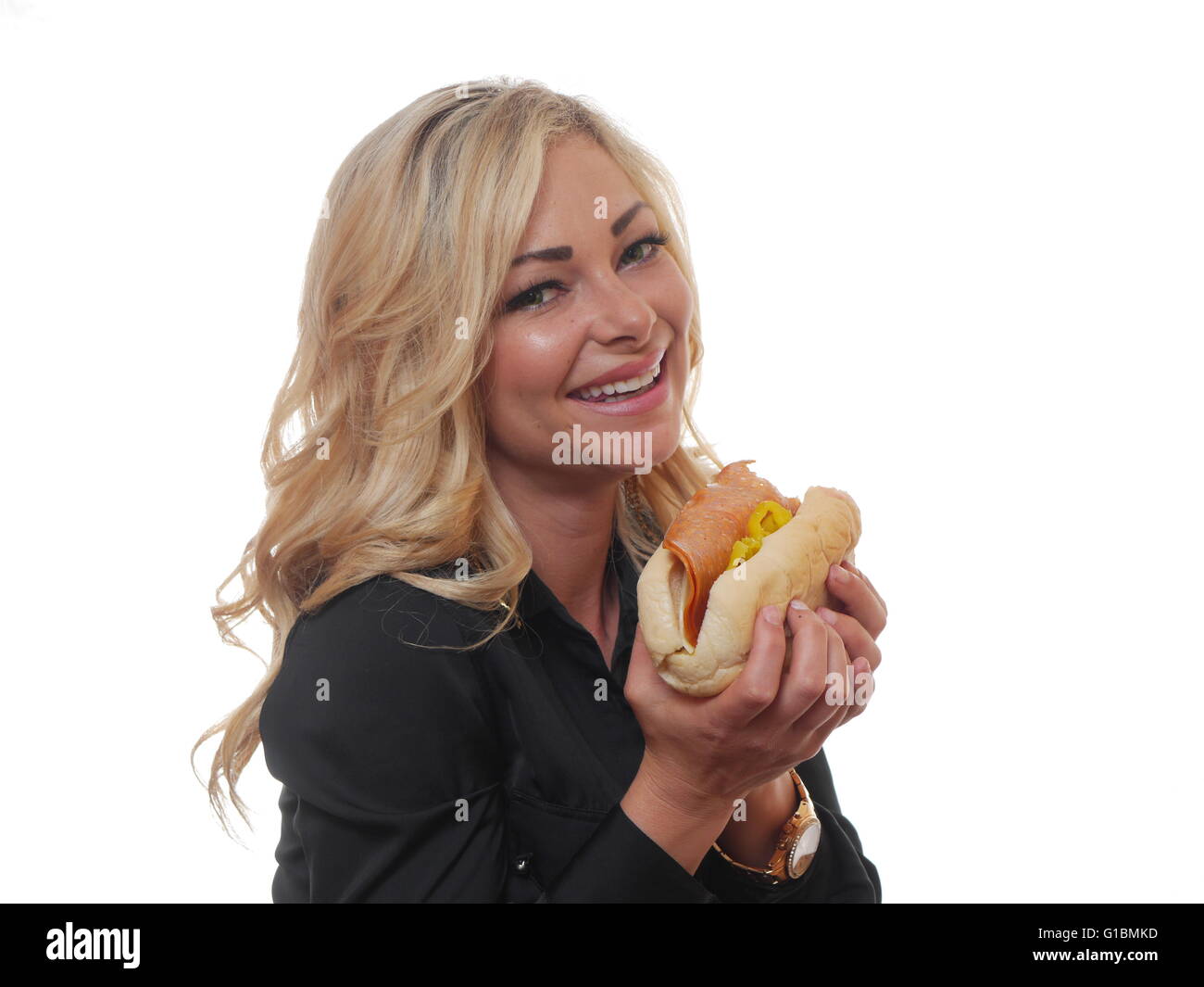 A pretty blond woman is eating a sandwich. Stock Photo
