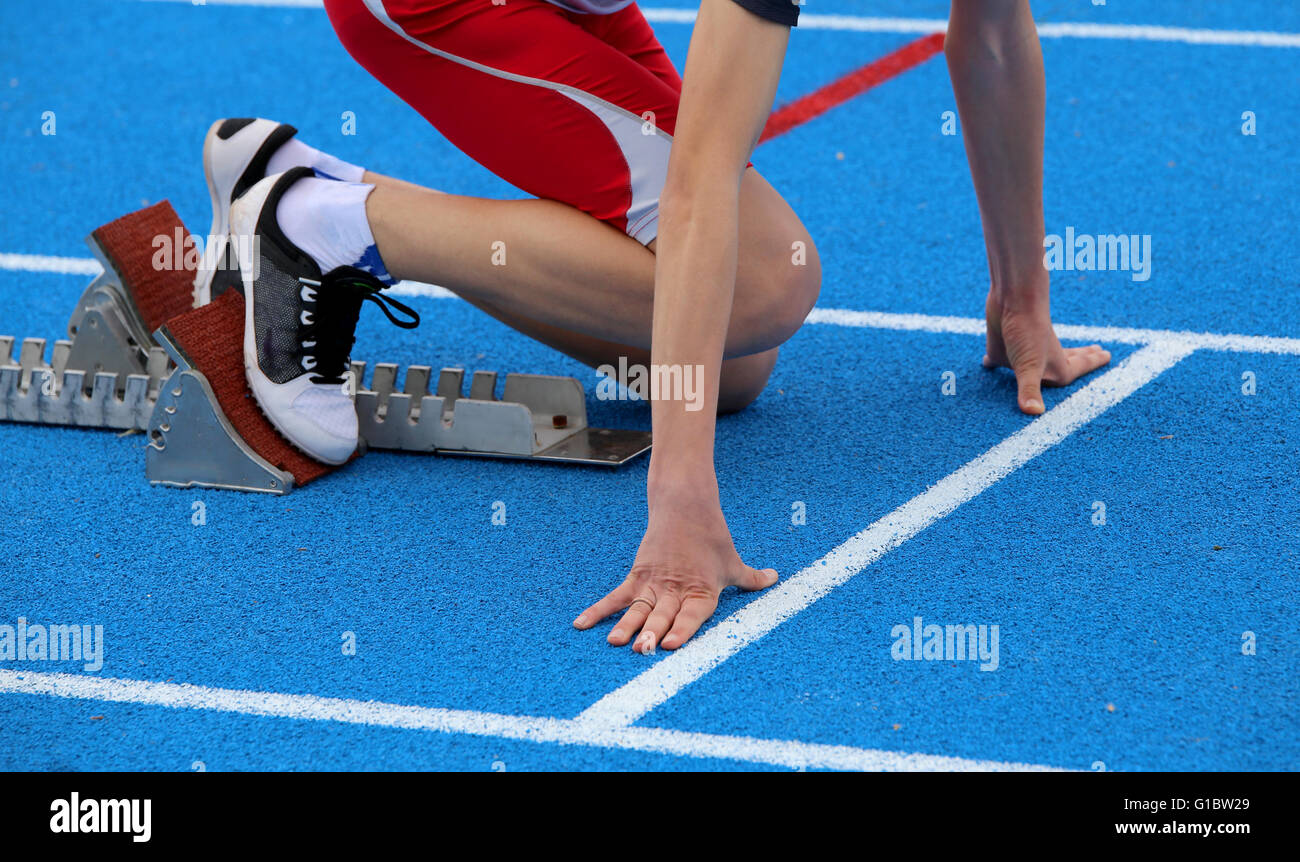 young athlete in the starting blocks of a athletic track before the