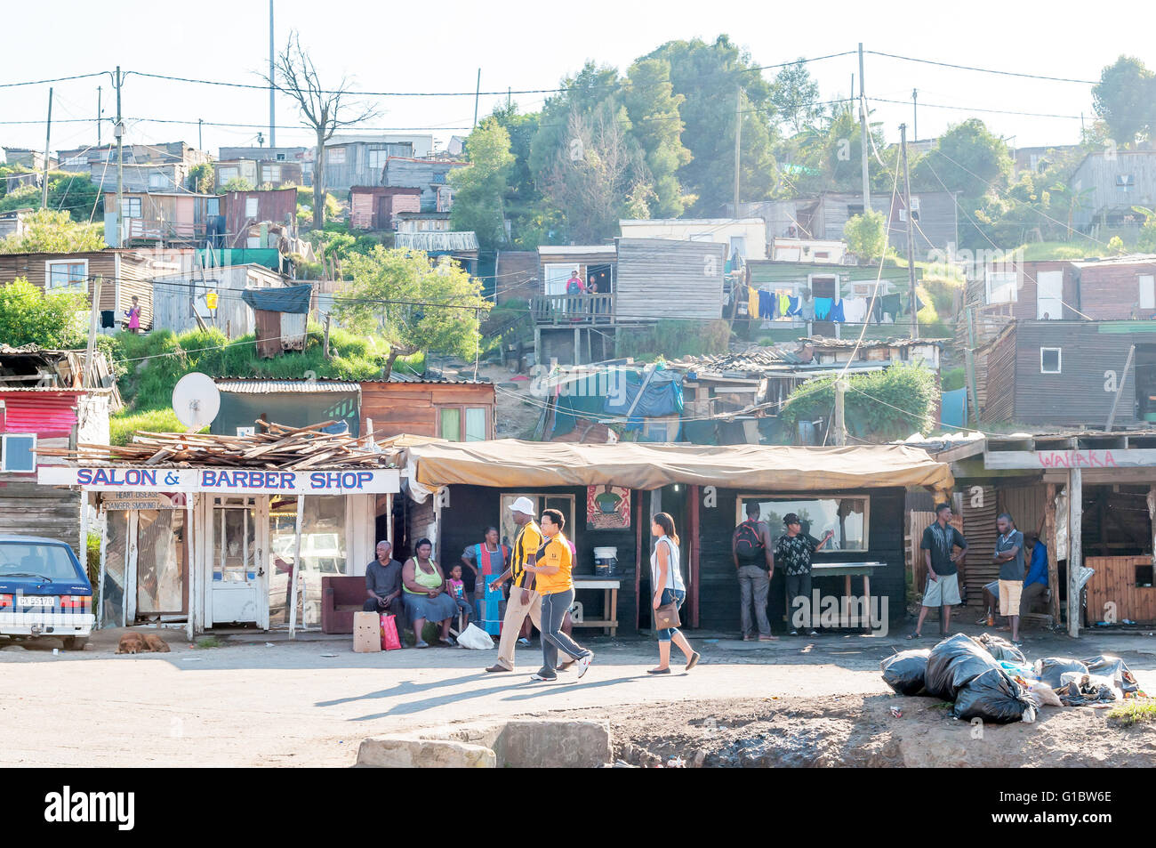 KNYSNA, SOUTH AFRICA - MARCH 5, 2016: Unidentified people in an morning scene of shacks and informal businesses in a township Stock Photo