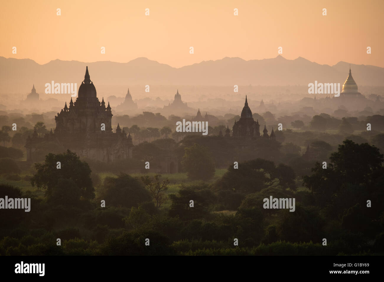 Dawn over the ancient temples in Bagan scattered through the misty landscape Stock Photo