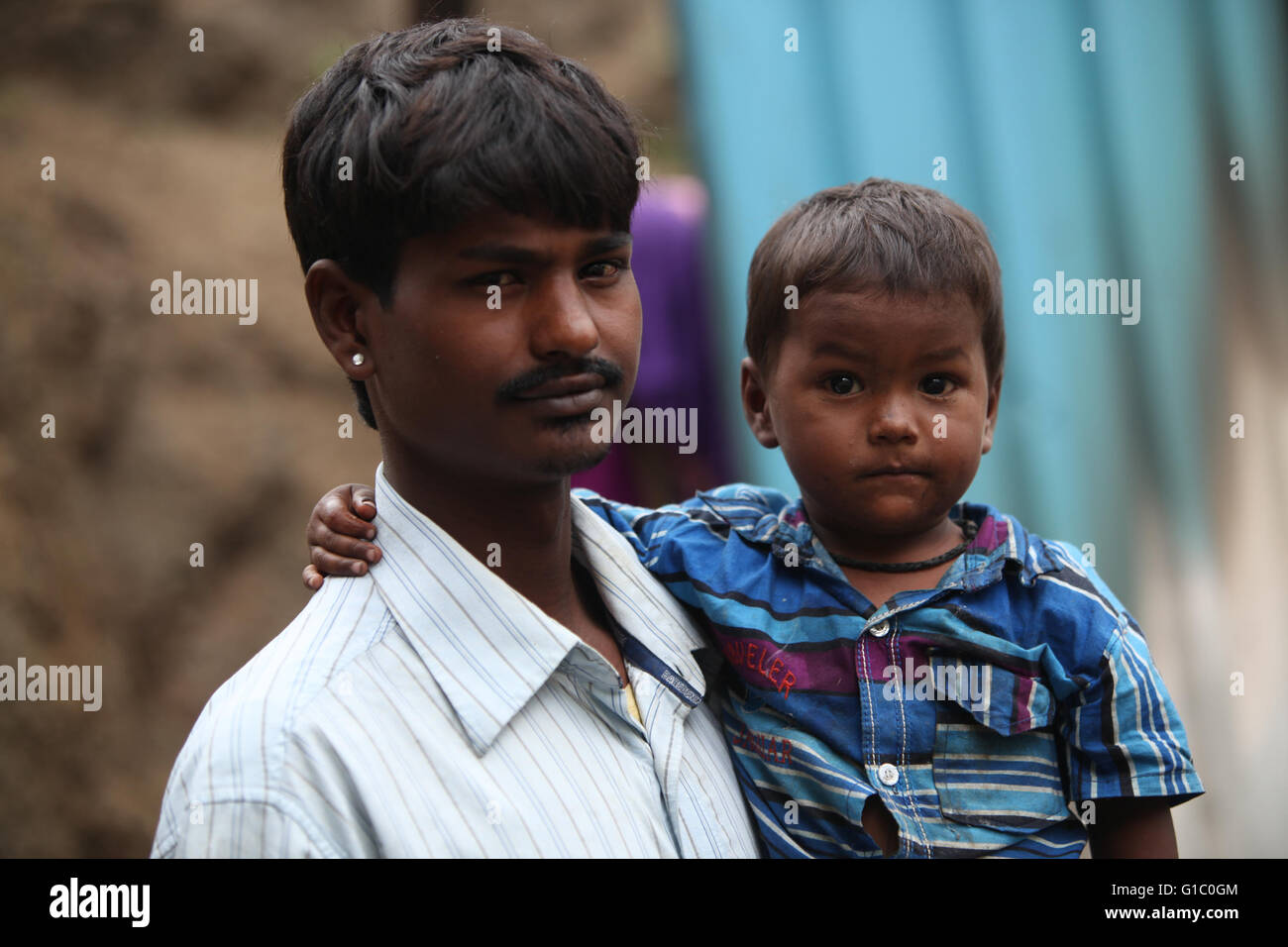Pune, India - July 16, 2015: A little boy with his poor father who is a construction worker, in India Stock Photo