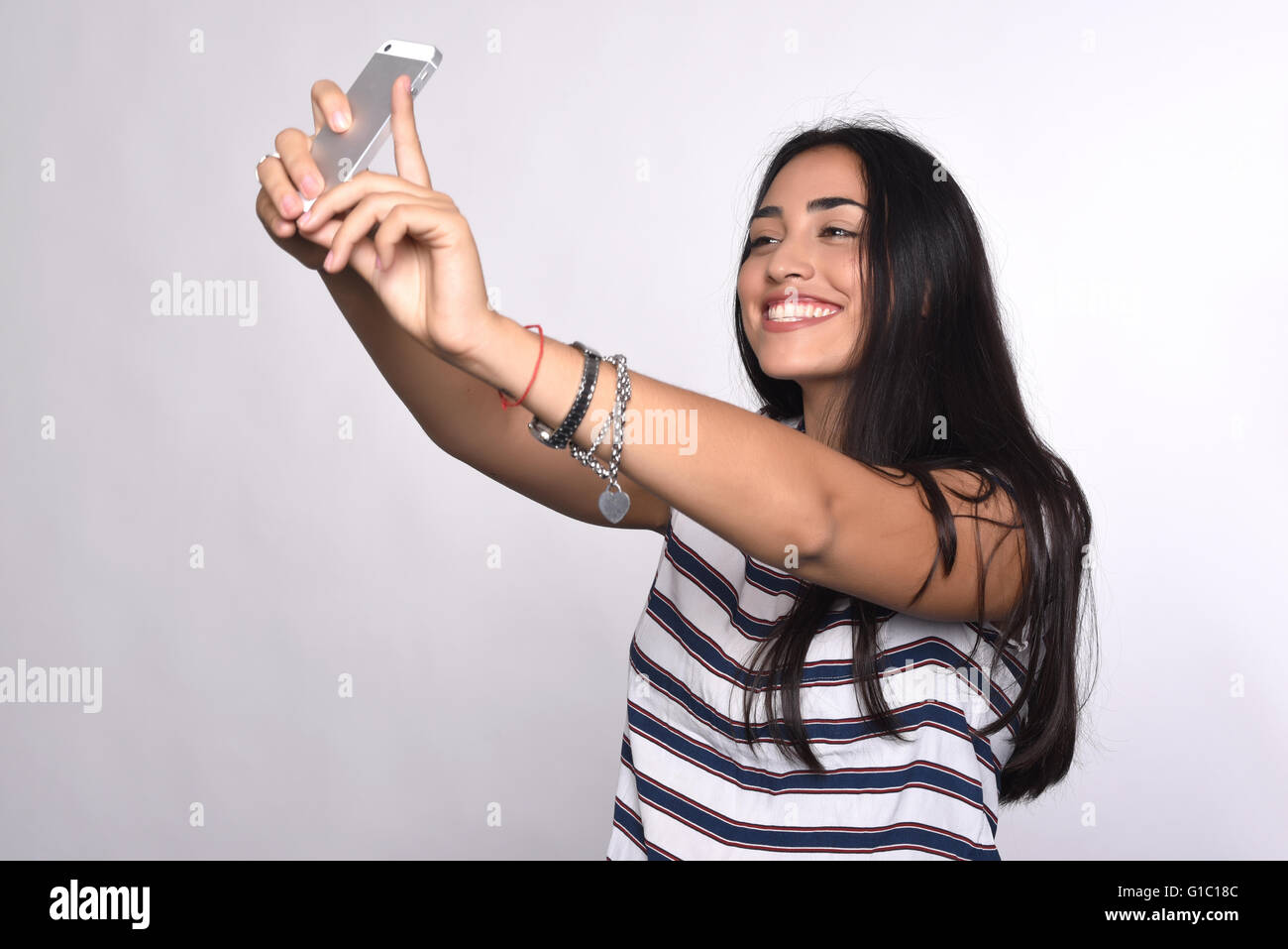 Young beautiful woman taking selfie with smartphone indoor. Isolated ...
