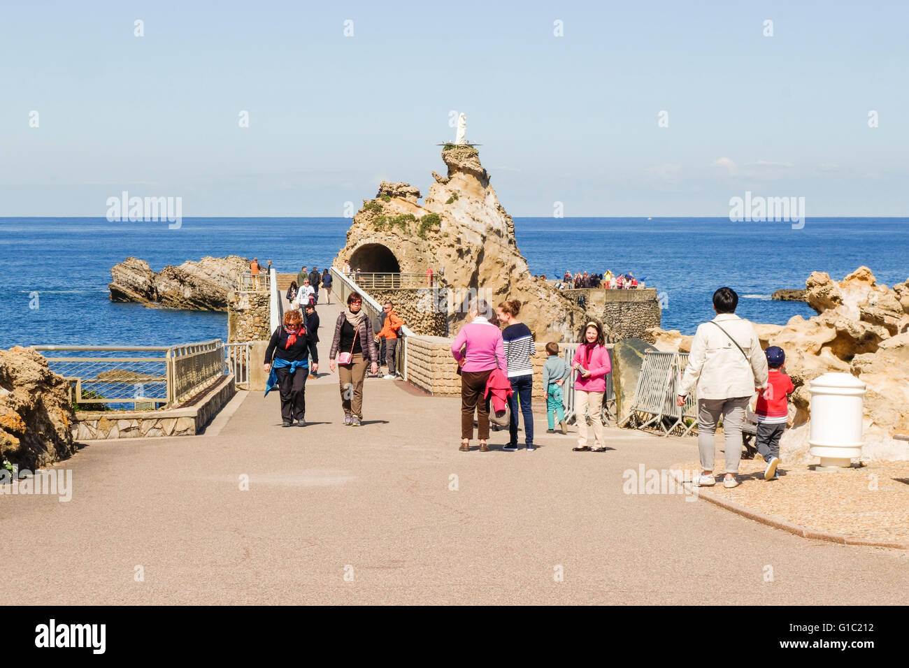 Tourists walk the bridge to la rocher de la vierge, virgin mary rock. Aquitaine, basque country, Biarritz, France. Stock Photo