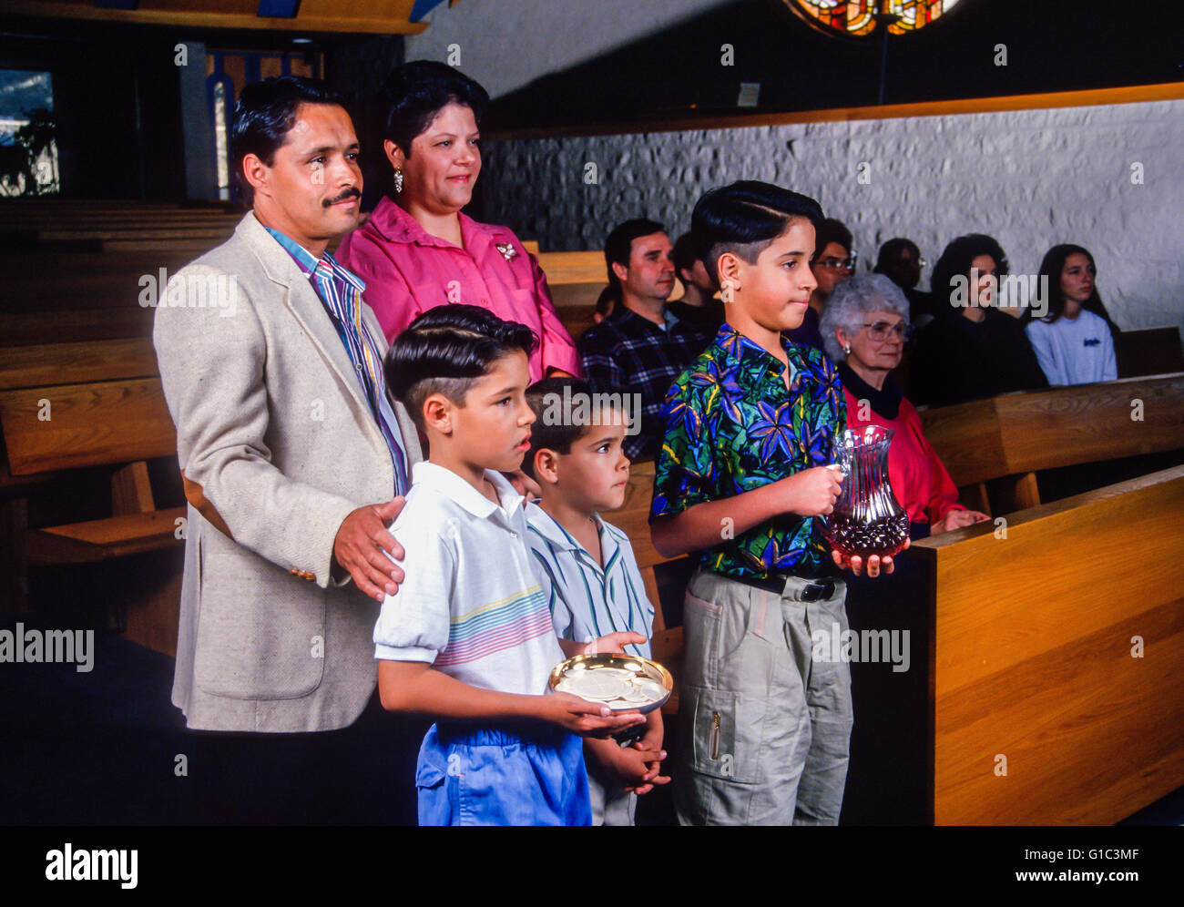 Hispanic Family bringing gifts to the altar in the Catholic Church. MR ©Myrleen Pearson Stock Photo