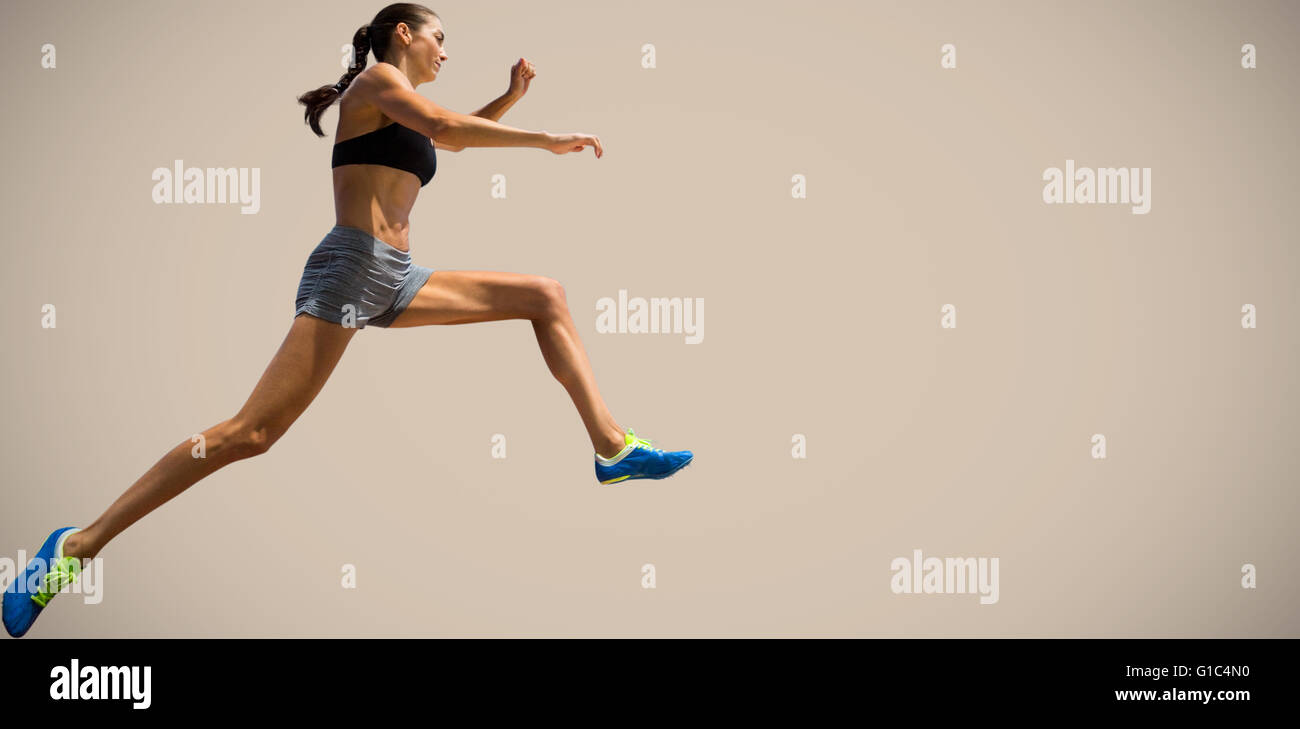 Composite image of profile view of sportswoman jumping Stock Photo