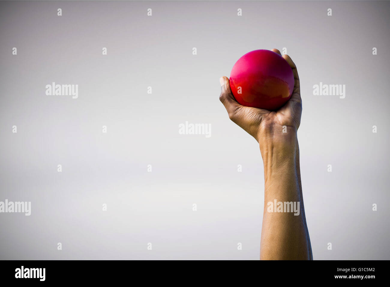 Composite image of hand holding a red ball Stock Photo