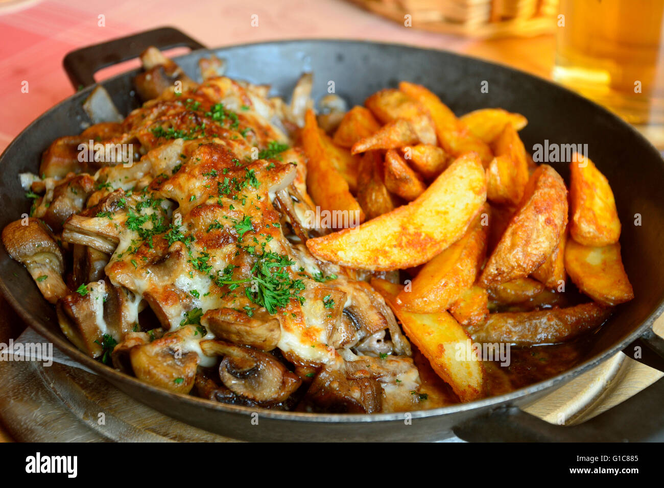 Pork steak with fried mushrooms and onions, gratinated with cheese