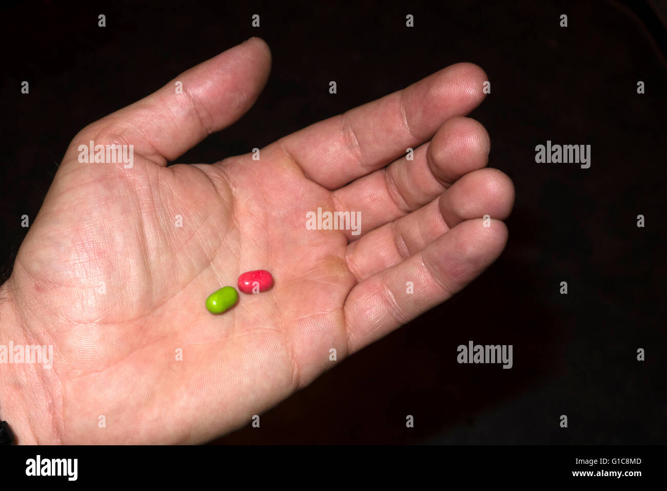 holding a red and a green pill Stock Photo - Alamy