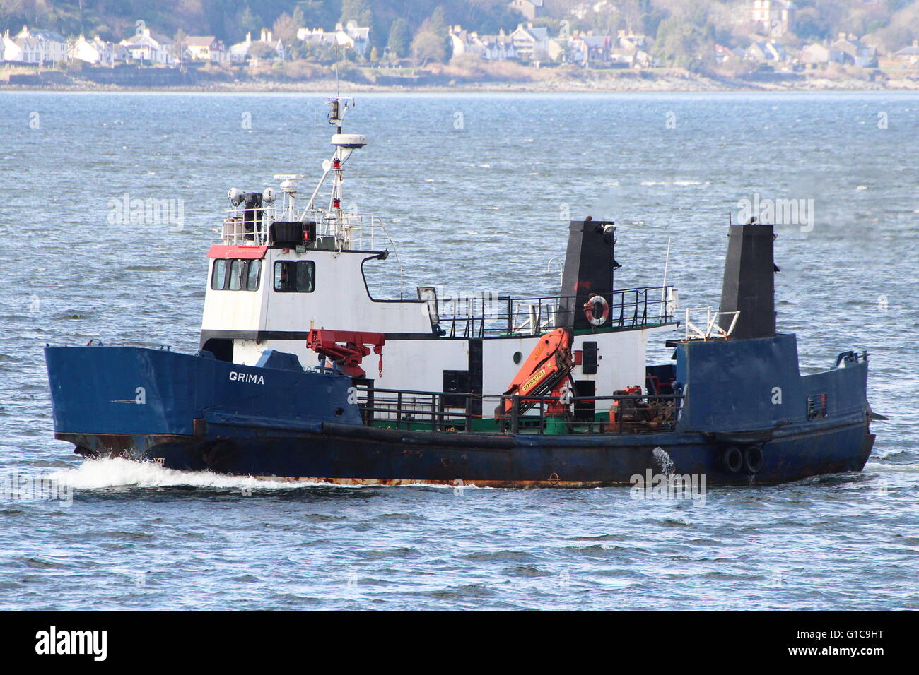 The workboat Grima, a former Shetland Islands Council ferry, passes Cloch Point on the Firth of Clyde. Stock Photo