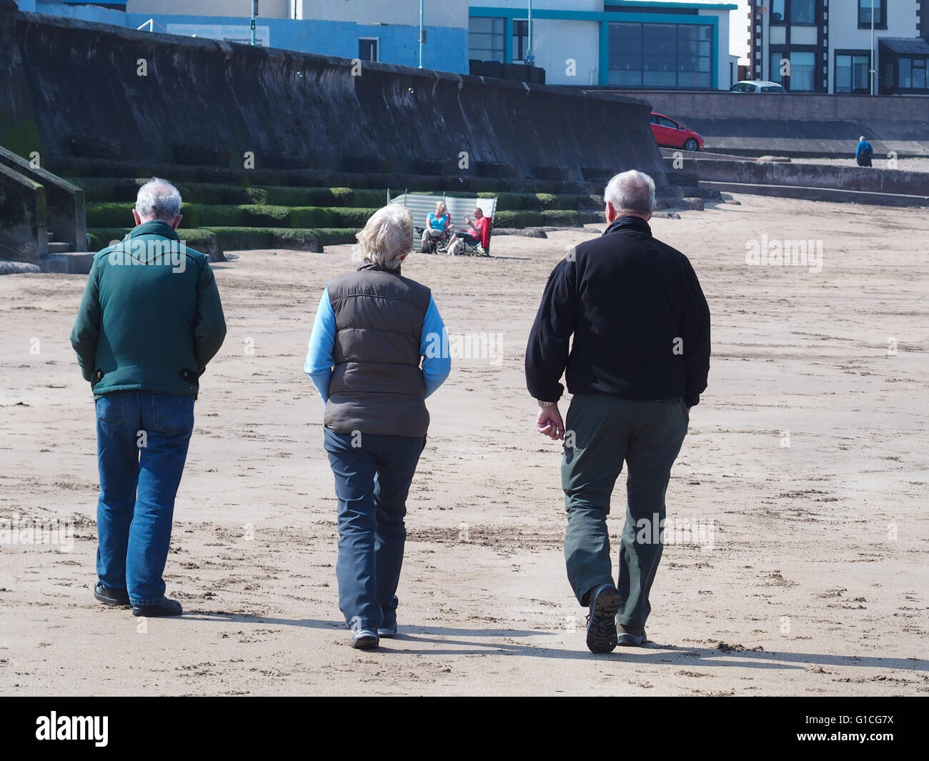 People walking on beach, Eyemouth Stock Photo