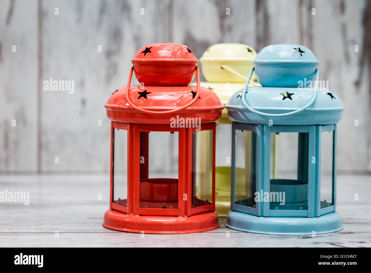Colorful candle holders on white wooden background Stock Photo