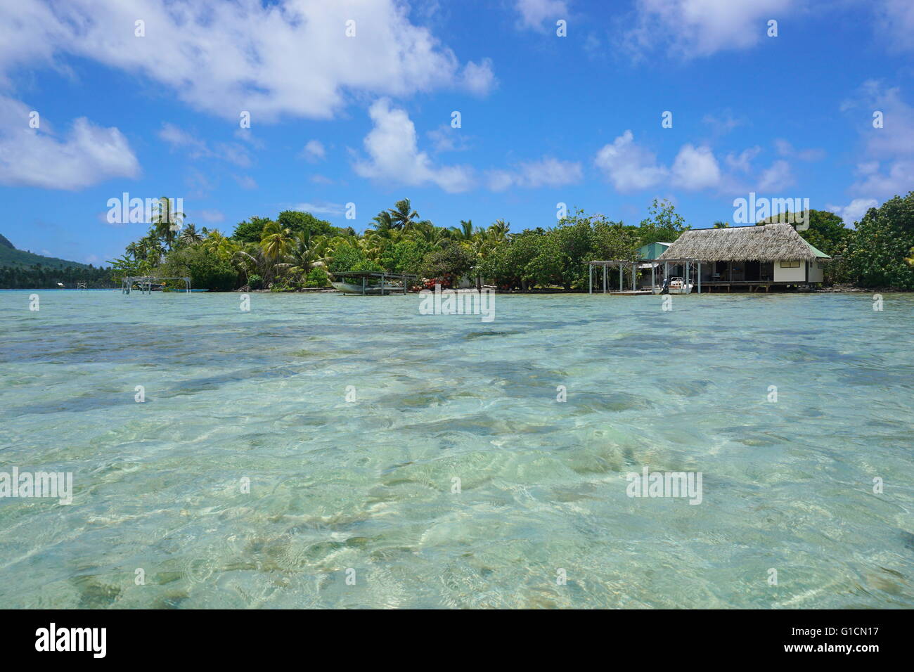 Shoreline of an islet with Polynesian home and shallow water of the lagoon, Huahine island, Pacific ocean, French Polynesia Stock Photo