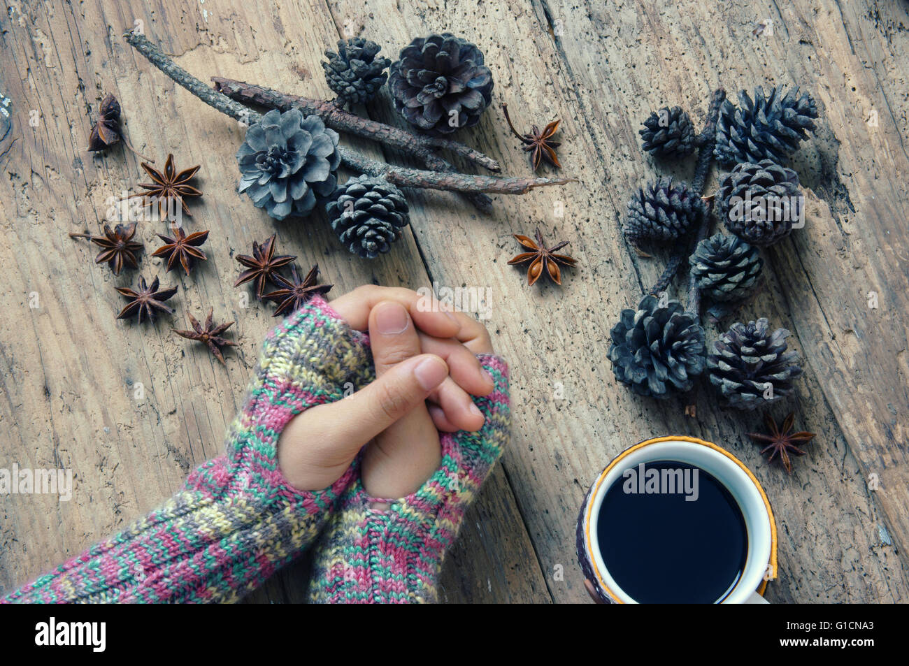 Women hand wear wool gloves in wintertime, lonely background in cold day of christmas season, hot coffee cup for winter Stock Photo