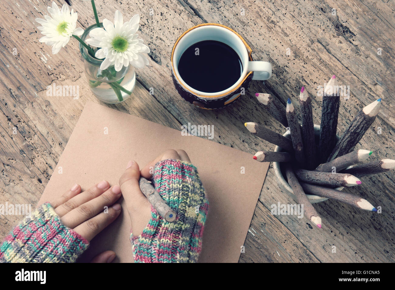 Women hand wear wool gloves in wintertime, writting letter for lover from distant, lonely  in cold day of christmas season with hot coffee cup Stock Photo