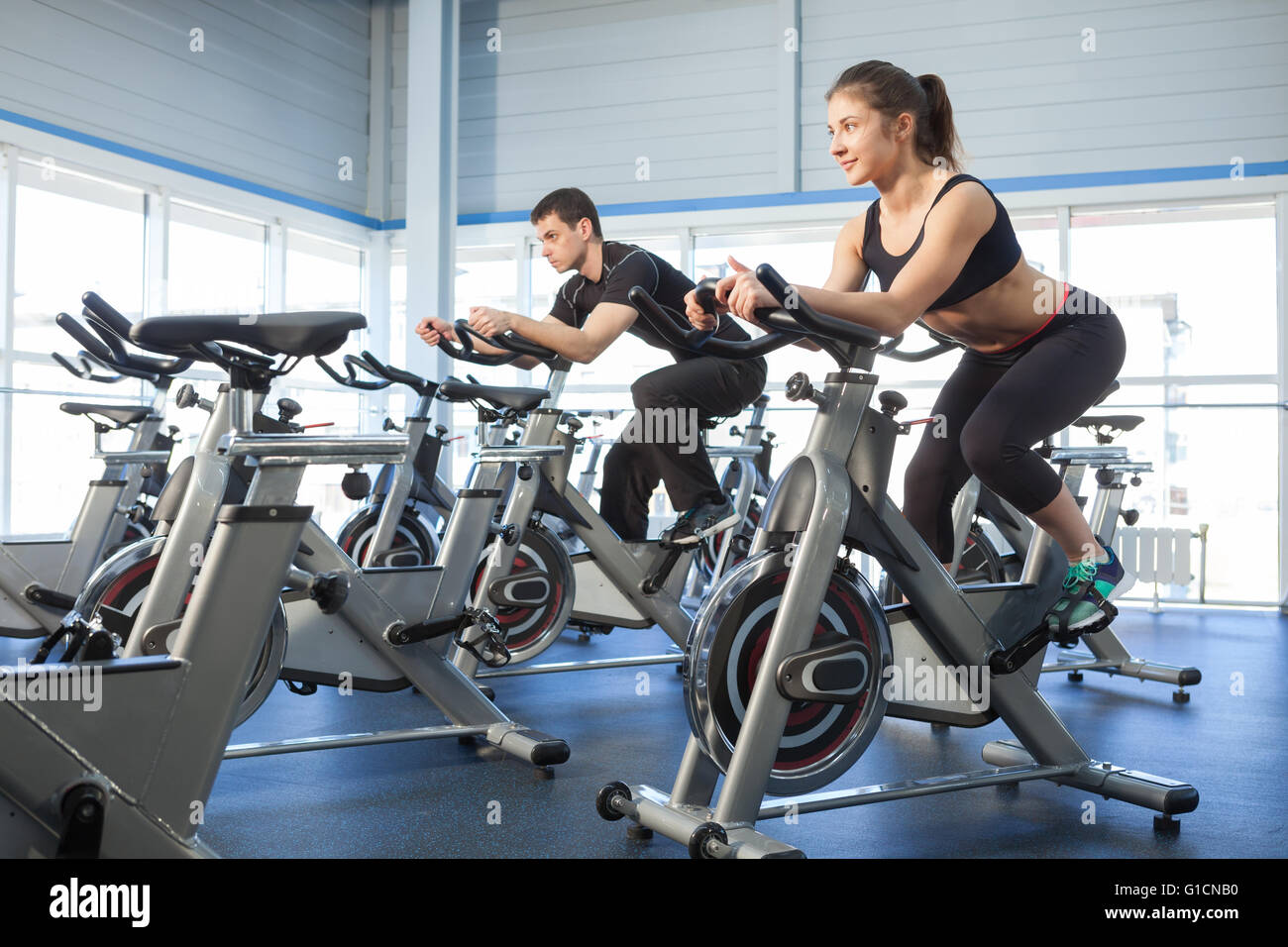 Man and woman exercise bikes at the gym Stock Photo - Alamy