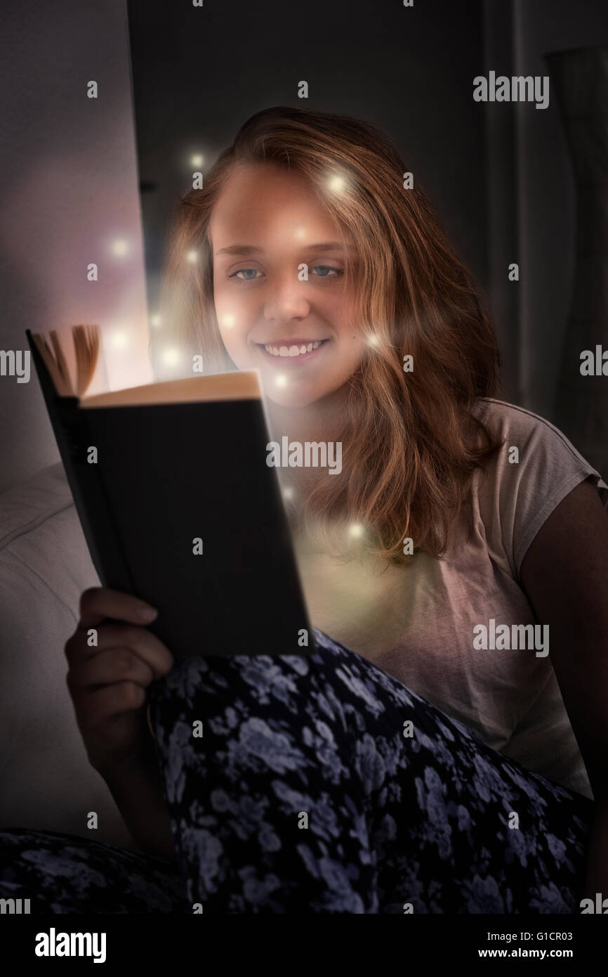 Beautiful young woman reading book in bed Stock Photo