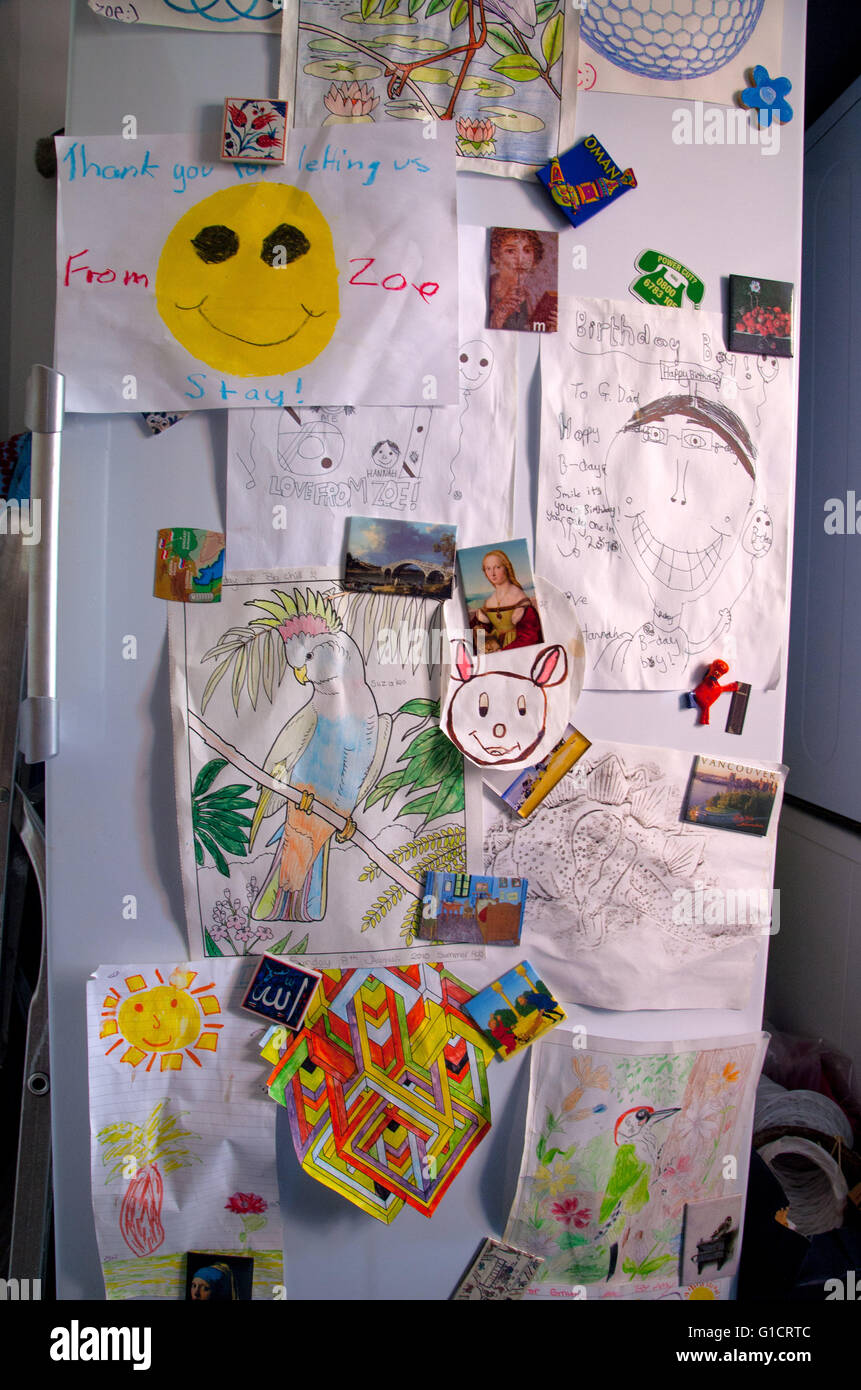 childrens-drawings-held-in-place-by-magnets-on-fridge-door-G1CRTC.jpg