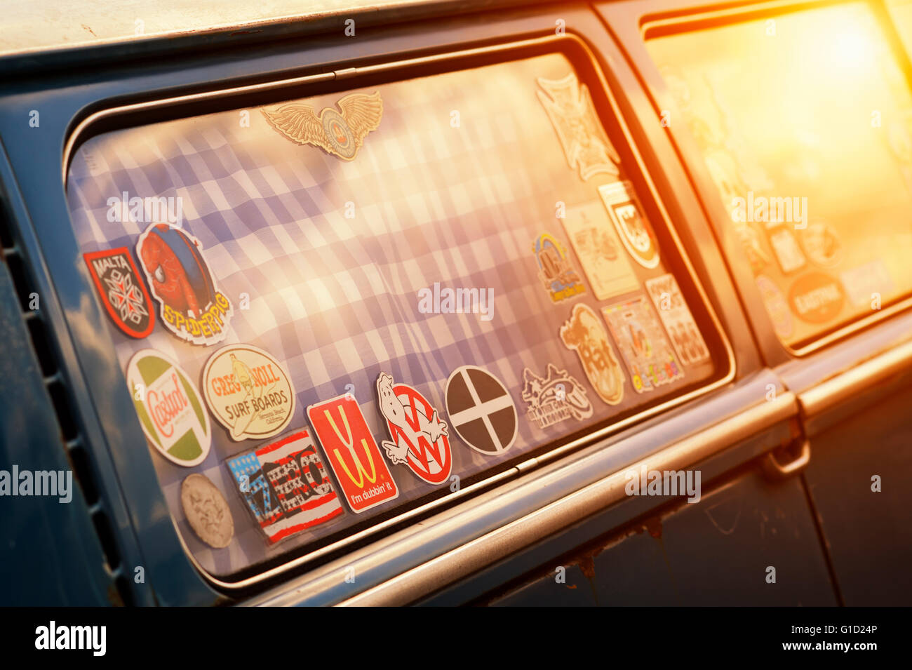 Stickers in the window of a VW Campervan with added nostalgic filter and dusky sun flare Stock Photo