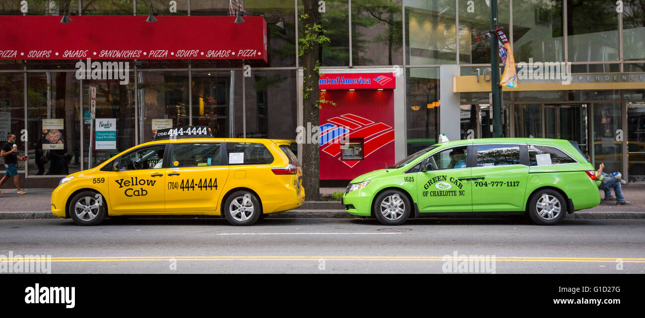 Charlotte, North Carolina A yellow cab and a green cab wait for fares on an uptown street