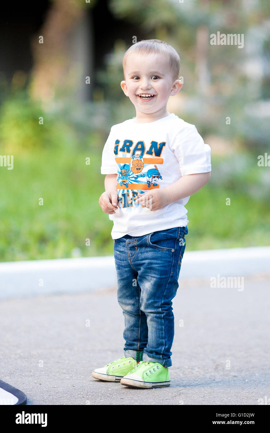 Stylish baby boy standing in the park Stock Photo - Alamy