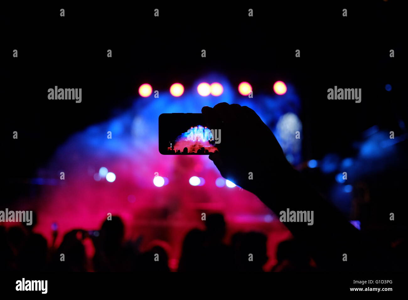 A person taking photos of a rock musical concert with a smartphone in the city of Eilat Israel Stock Photo