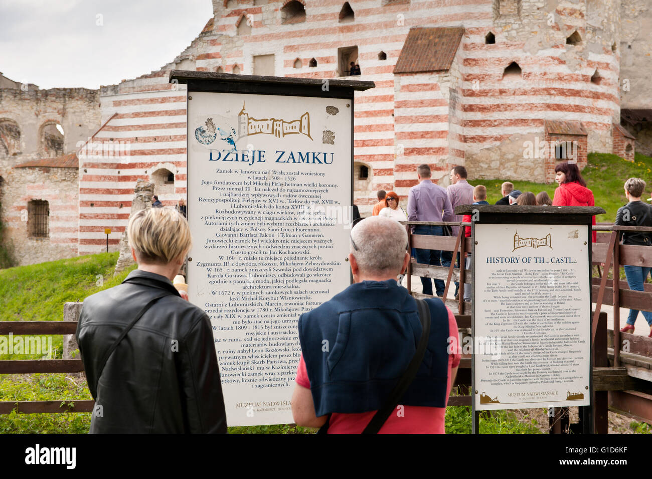 History of the Janowiec Castle, people reading the visitor information board in front of the bridge to historical building ruins Stock Photo