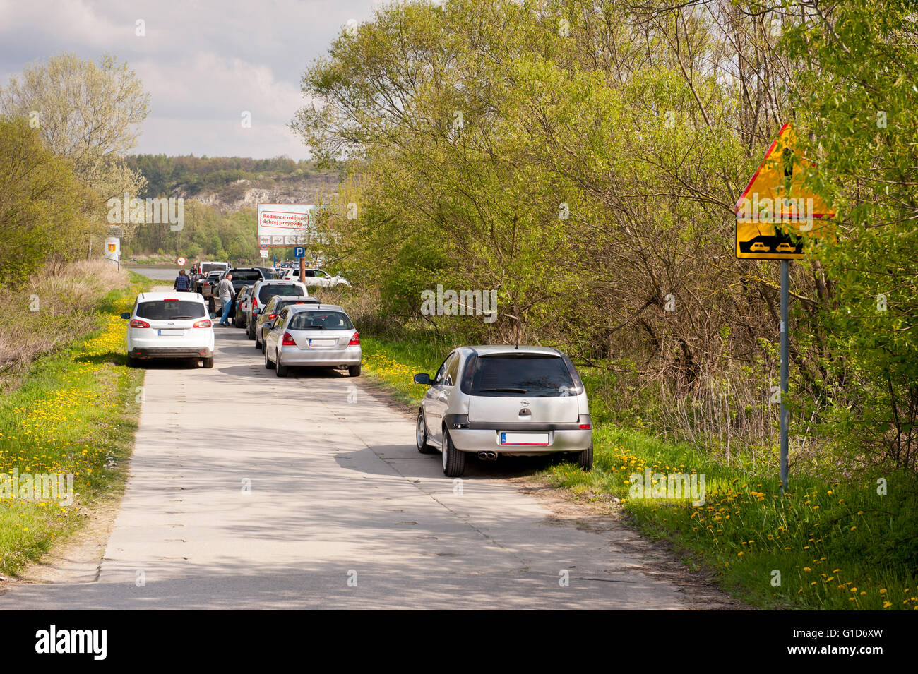 Cars queue to cable ferry ship and warning sign by the way, course to Kazimierz Dolny from Janowiec in Poland, Europe, travel. Stock Photo