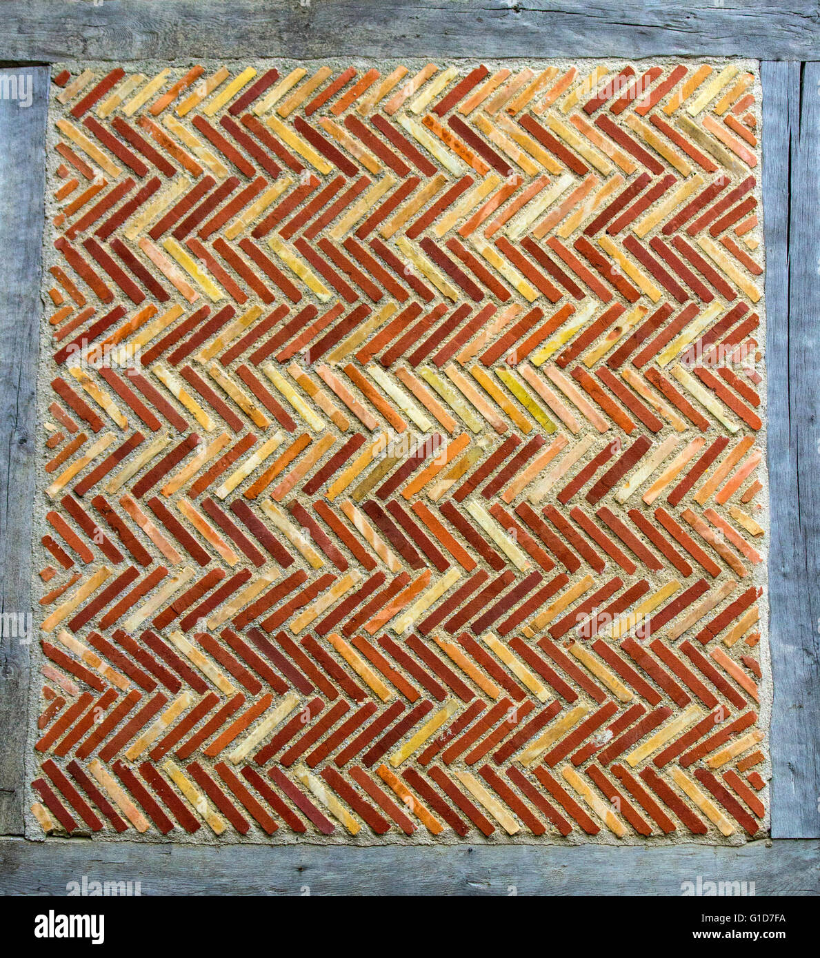 Section of wall constructed of roman bricks in a zigzag pattern surrounded by wood Stock Photo