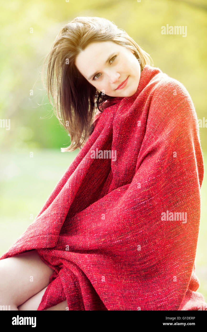 portrait of young woman wrapped in a red blanket outdoors Stock Photo ...