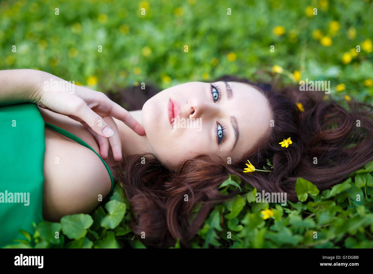 Attractive woman lying in the green grass Stock Photo - Alamy