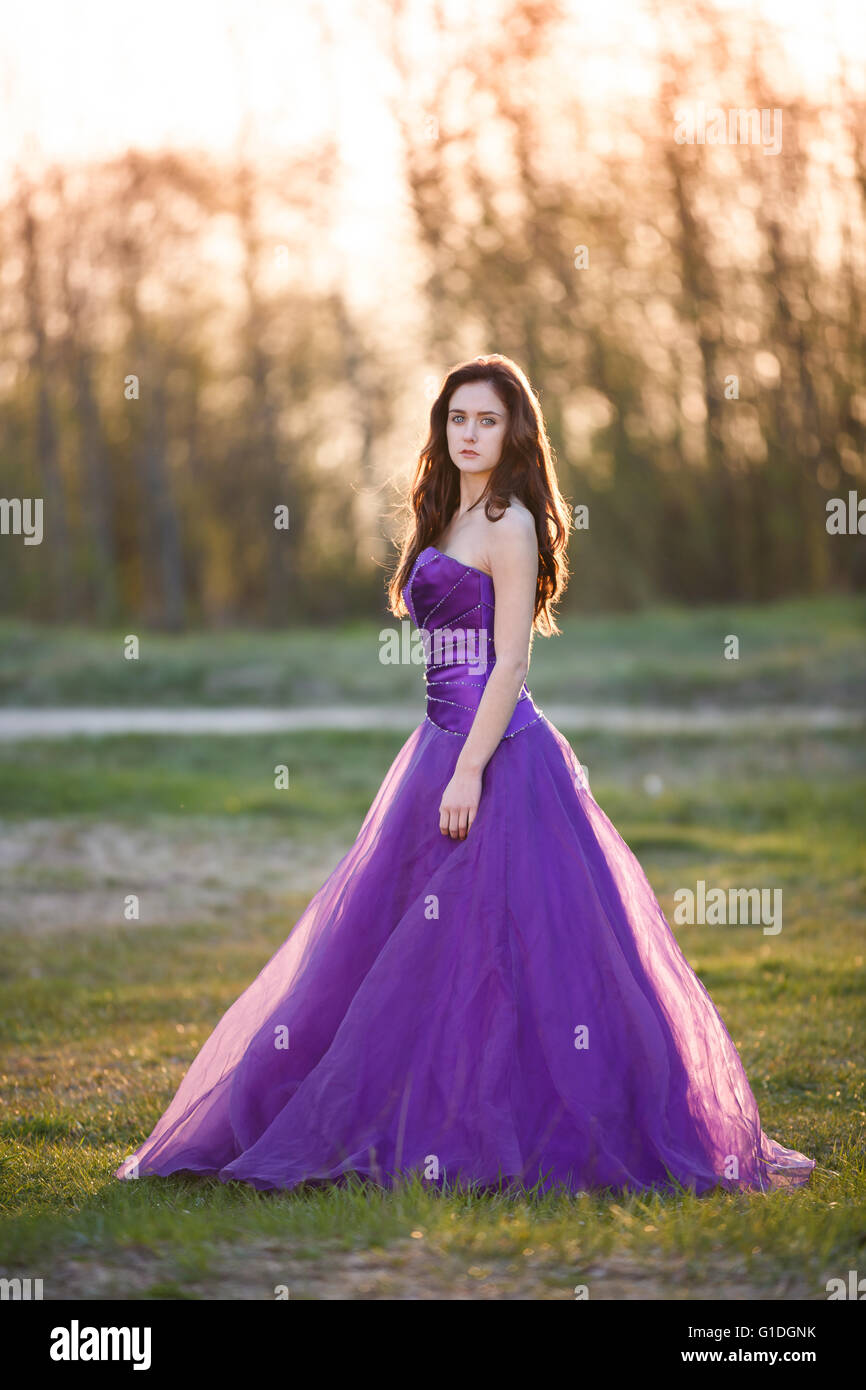 Attractive girl dressed evening gown at sunset Stock Photo