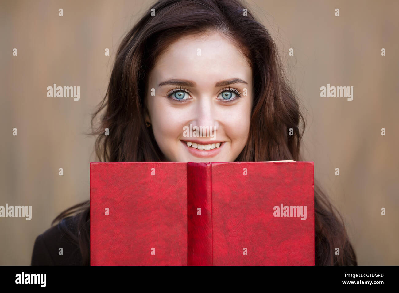 Portrait of attractive teenage girl with red book Stock Photo - Alamy