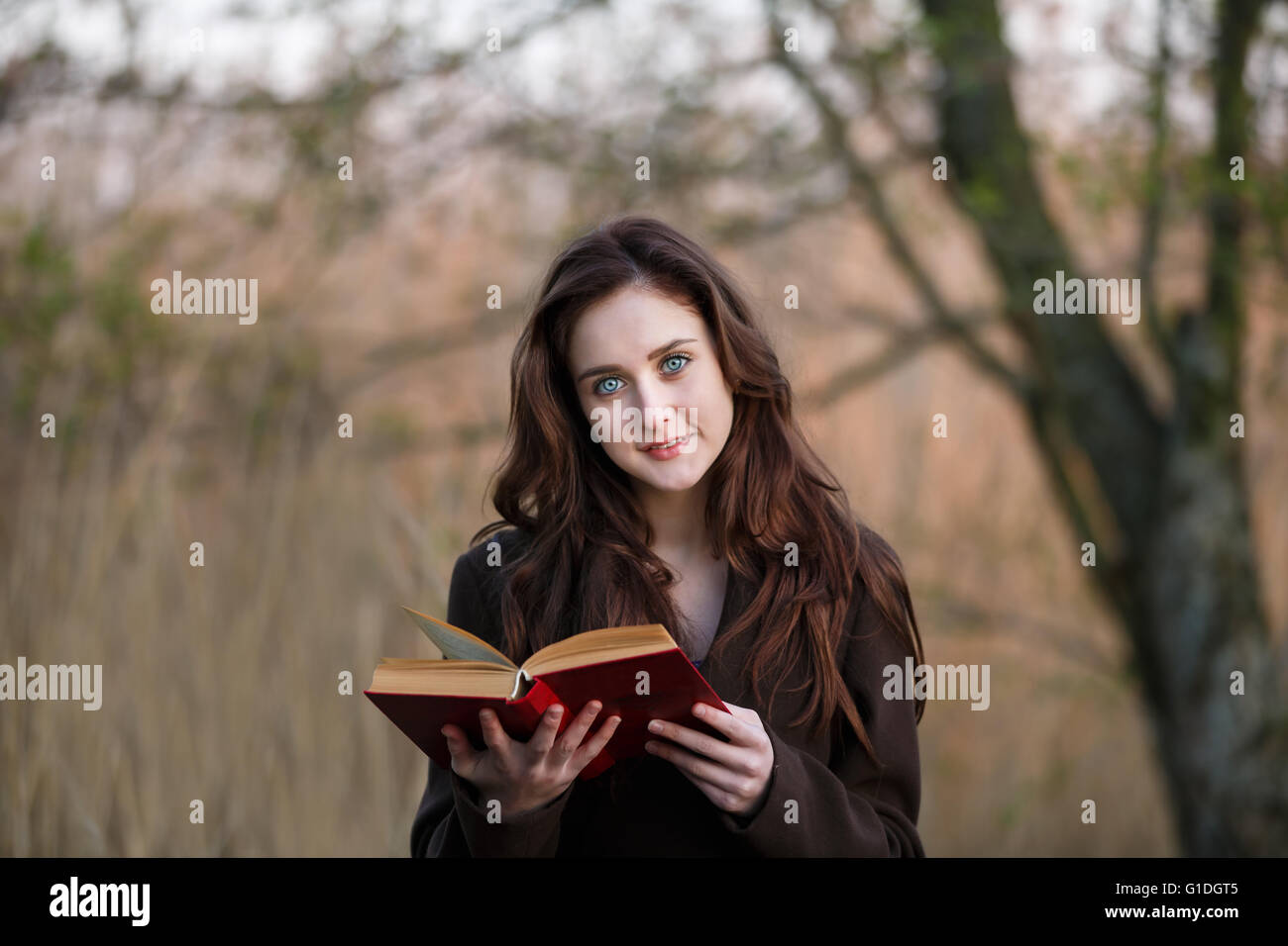 Portrait of attractive teenage girl with red book Stock Photo - Alamy