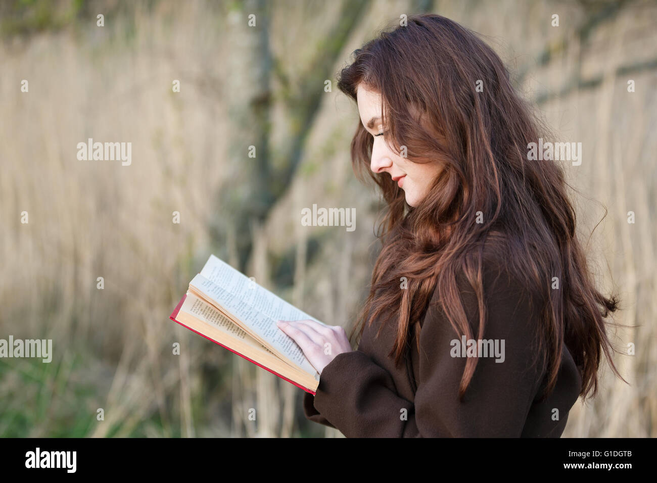 Portrait of attractive teenage girl with red book Stock Photo - Alamy