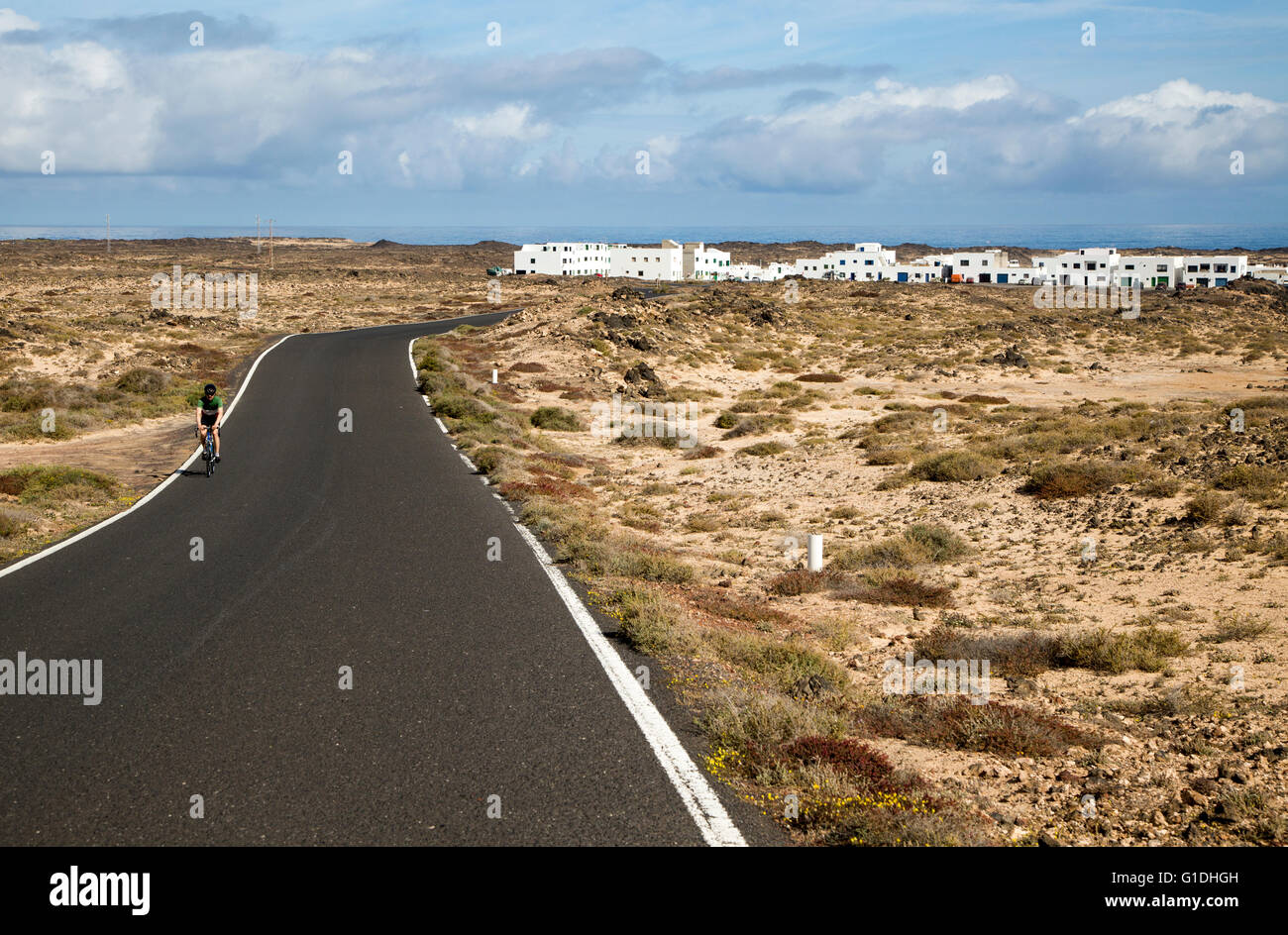 Cyclist on road at Caleta de Caballo village, Lanzarote, Canary islands, Spain Stock Photo