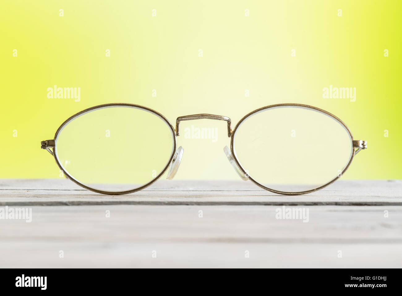 Glasses lying on a table on green background Stock Photo - Alamy