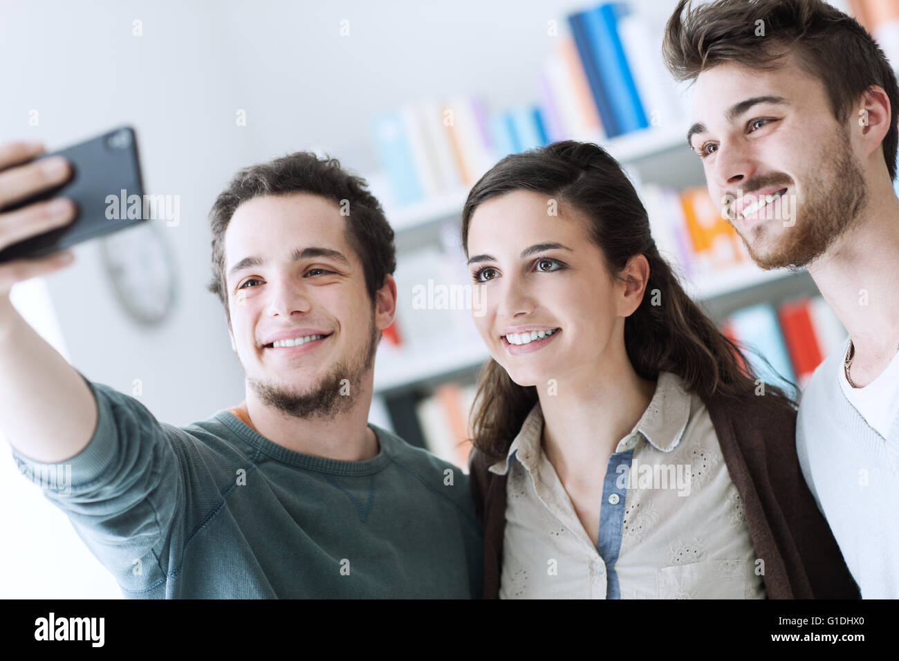 Smiling happy teenagers taking selfies with a mobile phone, sharing, technology and friendship concept Stock Photo