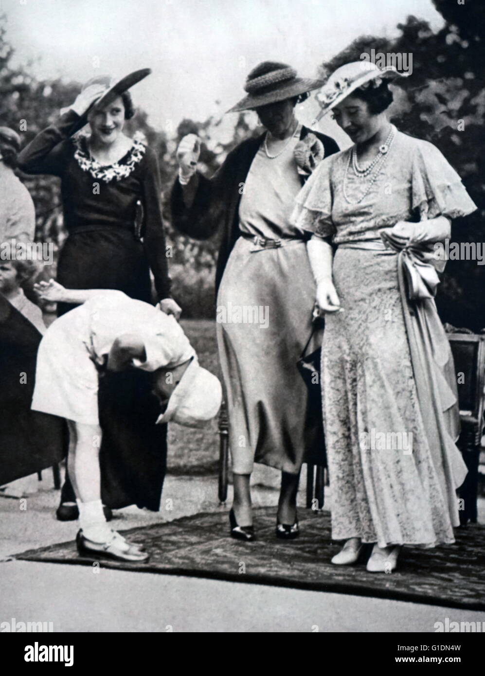 Photograph of Lady Elizabeth (1900-2002) attending a garden party at St. James's Palace in aid of the National Council for Maternity and Child Welfare. Dated 20th Century Stock Photo