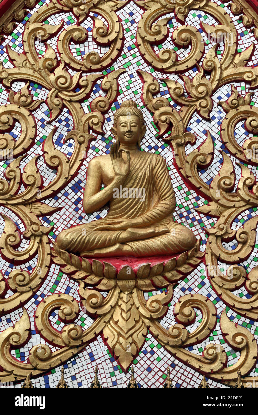Entrance door ornamented with gold reliefs. The Teaching Buddha depicts a particular moment in the life of the Buddha, namely, t Stock Photo